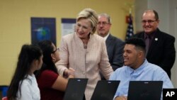 Democratic presidential candidate Hillary Clinton talks with students as she tours classrooms at John Marshall High School in Cleveland, Aug. 17, 2016, before participating in a campaign event.
