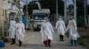 ရန်ကုန်မြို့ရှိ Quarantine Center တခုအပြင်ဘက်မှာ တွေ့ရတဲ့ PPE ဝတ်စုံဝတ် စေတနာ့ဝန်ထမ်းများ။ (အောက်တိုဘာ ၁၂၊ ၂၀၂၀)