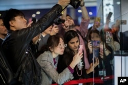 FILE - Attendees take pictures of the new Huawei Mate X foldable 5G smartphone during the Mobile World Congress wireless show, in Barcelona, Spain, Feb. 25, 2019.