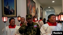 中国天主教徒2018年12月24日在上海的圣诞节前夕参加教堂弥撒，穿迷彩服者为保安人员。