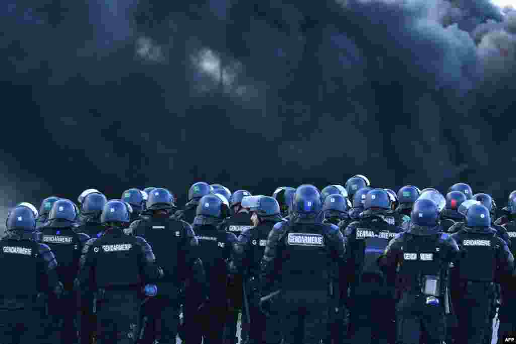 French gendarmes arrive for evacuation as prison guards block the entrance to the penitentiary center of Alencon, in Conde-sur-Sarthe, northwestern France, two days after a prison inmate seriously wounded two guards in a knife attack before being detained in a police raid.