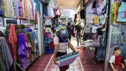 A youth wearing a face mask walks in a shopping mall as it reopened after restrictions to halt the spread of the COVID-19 coronavirus were lifted in Yangon on May 17, 2020. (Photo by Sai Aung Main / AFP)