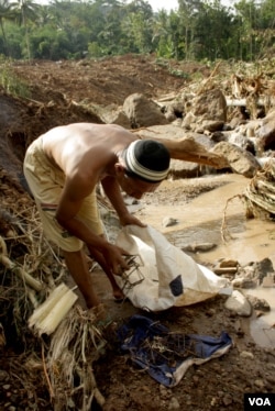 Marsudi, korban bencana tanah longsor Purworejo, mengumpulkan besi bekas dari reruntuhan rumahnya yang hancur (Foto: VOA/Nurhadi)