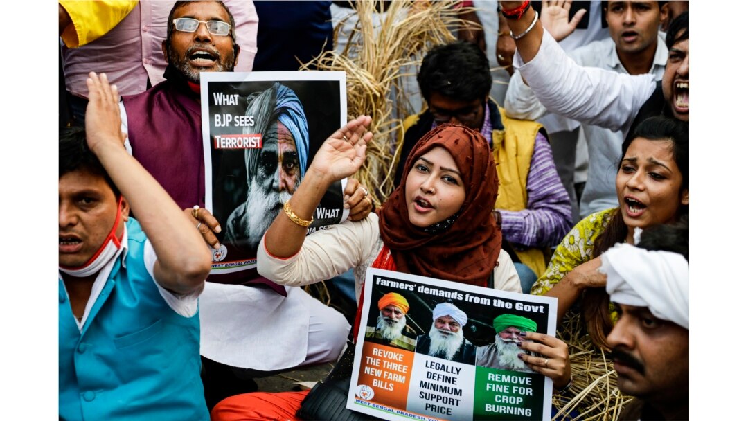 Para pendukung Partai Kongres Nasional India meneriakkan slogan-slogan untuk mendukung protes petani yang sedang berlangsung selama pawai di luar Istana Gubernur, di Kolkata, India, Senin, 14 Desember 2020. (AP Photo / Bikas Das)