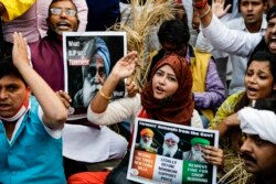 Para pendukung Partai Kongres Nasional India meneriakkan slogan-slogan untuk mendukung protes petani yang sedang berlangsung selama pawai di luar Istana Gubernur, di Kolkata, India, Senin, 14 Desember 2020. (AP Photo / Bikas Das)