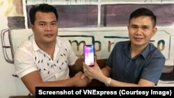 Thái Minh Phương (trái) và Mạnh Tài cùng cầm chiếc điện thoại có 'siêu SIM' mang 8 số 9. Số điện thoại này được bán với giá 1 triệu USD. (Ảnh chụp màn hình VNExpress)