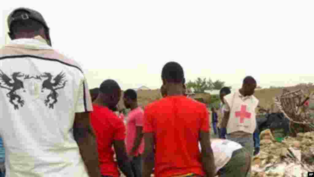 Mutane sunyi dafifi kewaye da inda daya daga cikin boma-boman ya tashi domin ganewa idanusu a Ajilari-Gomari kusa da filin jirgin sama na Maiduguri a ranar 2 ga watan Maris 2014.