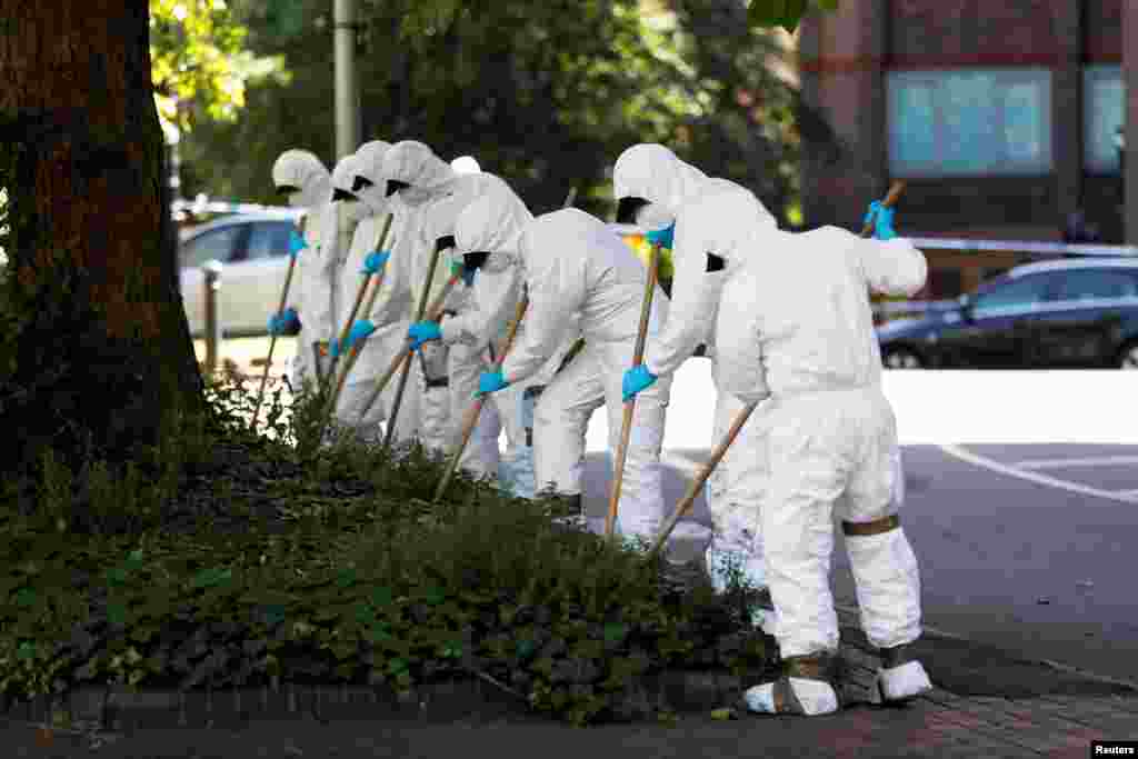 Forensic officers search near the scene of reported multiple stabbings in Reading, Britain.