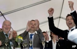 AfD member Alexander Gauland, left, and Leif-Erik Holm, center, top candidate of the AfD, celebrate at the gathering of the AfD (Alternative for Germany) party in Schwerin, Germany, Sept. 4, 2016.