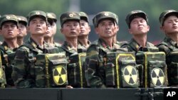 Солдати КНДР з пакетами з ядерною символікою