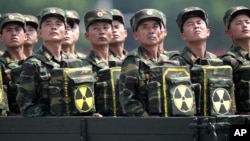 FILE - North Korean soldiers, carrying packs marked with a nuclear symbol, turn and look toward leader Kim Jong Un as they parade during a ceremony marking the 60th anniversary of the Korean War armistice in Pyongyang, North Korea, July 27, 2013. The U.S.