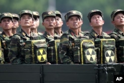 FILE - North Korean soldiers, carrying packs marked with a nuclear symbol, turn and look toward leader Kim Jong Un as they parade during a ceremony marking the 60th anniversary of the Korean War armistice in Pyongyang, North Korea, July 27, 2013.