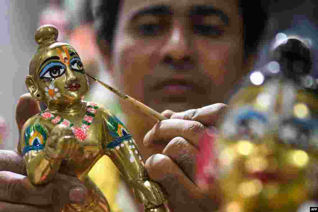 An artist gives finishing touches to an idol of Hindu deity Lord Krishna at a workshop in Amritsar, ahead of the Janmashtami festival which is celebrated to mark the birth of Krishna.