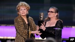 In this 2015 photo, Carrie Fisher, right, presents her mother Debbie Reynolds with the Screen Actors Guild life achievement award at the 21st annual Screen Actors Guild Awards in Los Angeles. (Photo by Vince Bucci/Invision/AP, File)