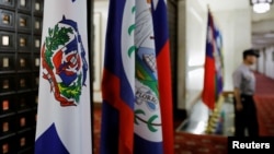 A police officer stands next to the Dominican Republic flag, left, inside the Taiwan's Ministry of Foreign Affairs in Taipei, Taiwan, May 1, 2018. 