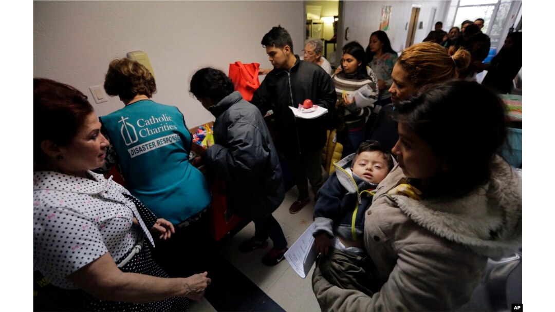 Darly Sotto, 21, of Guatemala holds her son, 1-year-old Jorge Sotto, as people check into the Catholic Charities shelter in McAllen, Texas, Jan. 11, 2019.