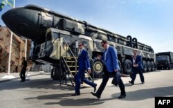 RUSSIA -- Military specialists walk past a Russian Topol intercontinental ballistic missile (ICBM) at the exposition field in Kubinka Patriot Park outside Moscow, August 22, 2017