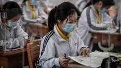 Учні школи у китайському місті Ухань сидять у класі за прозорими перегородками. 6 травня 2020 р.