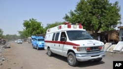 FILE - An ambulance and security vehicles are seen driving to the site of a June 2, 2015, suicide bomb attack in Maiduguri, Nigeria.