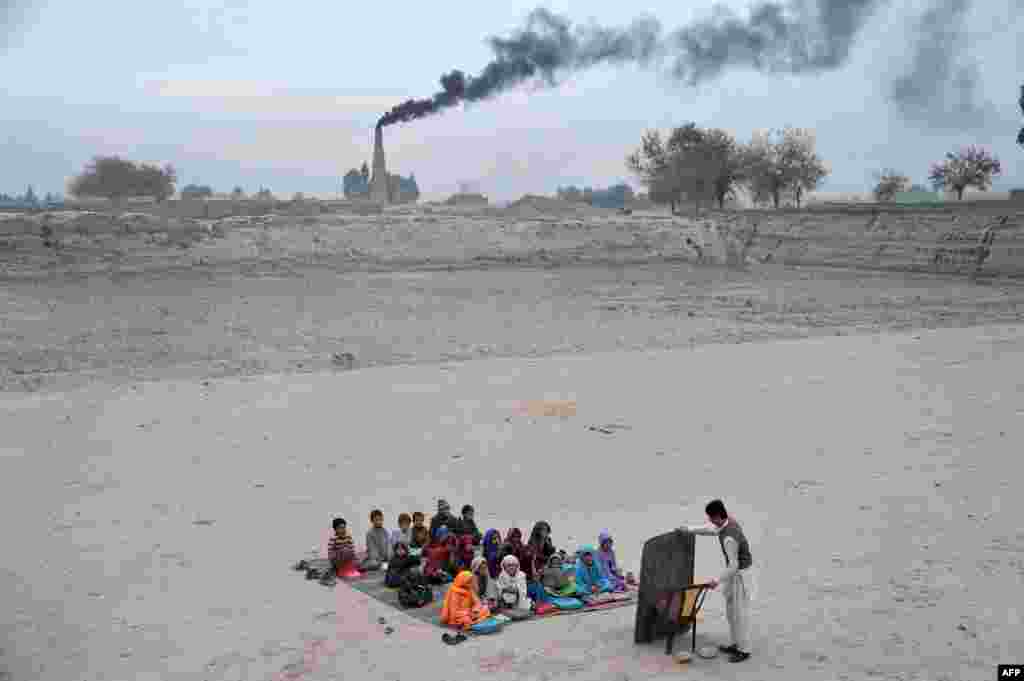 Anak-anak sekolah Afghanistan menerima pelajaran sekolah di kelas terbuka di sebuah kamp pengungsi di pinggiran kota Jalalabad, provinsi Nangarhar, Afghanistan.