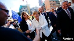 Tổng thống Đức Joachim Gauck (phải) và Thủ tướng Angela Merkel (giữa) gặp gỡ người dân trên đường phố ở Frankfurt hôm 3/10 khi Đức đánh dấu ngày thống nhất đất nước. 
