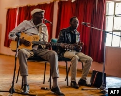 Zimbabwe music icon Oliver 'Tuku' Mtukudzi (L) plays his guitar during a rehearsal with a group of young musicians who are incubated at his Pakare Paye Arts and Music Centre in Norton 45km from the country's capital city Harare on January 12, 2018