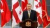 With Georgian and Turkish flags in the background, Turkish Prime Minister Recep Tayyip Erdogan speaks at a news conference in Tbilisi, Georgia, Aug. 14. 2008.