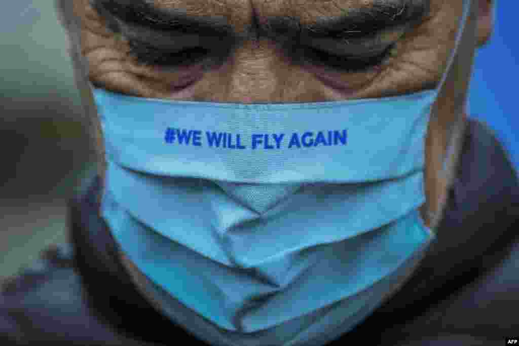 A TAP Air Portugal employee wearing a face mask reading &quot;We will fly again&quot; takes part in a protest against job cuts at TAP airline headquarters in Lisbon, Portugal.