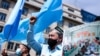 FILE - Demonstrators from the Uyghur community gesture as they take part in a protest near the Belgium parliament in Brussels, July 8, 2021. 