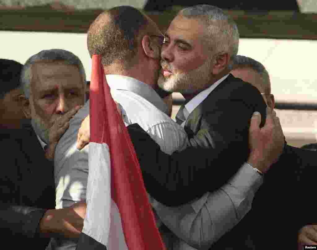 Senior Hamas leader Ismail Haniyeh hugs the brother of Hamas military chief Ahmed Jaabari, who was killed by an Israeli air strike, during a rally in Gaza City November 22