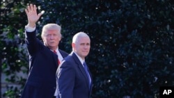 FILE - President Donald Trump, left, accompanied by Vice President Mike Pence, waves to members of the media as they walk to the Oval Office of the White House in Washington, Jan. 25, 2017