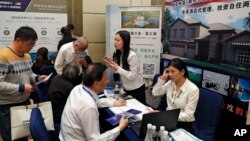 在妮可庫什納（Nicole Kushner Meyer現身北京的一場投資移民項目（EB-5）推介會的一天之後，在投資美國展覽中，在EB-5簽證項目攤位上，中國人詢問信息（2017年5月7日）