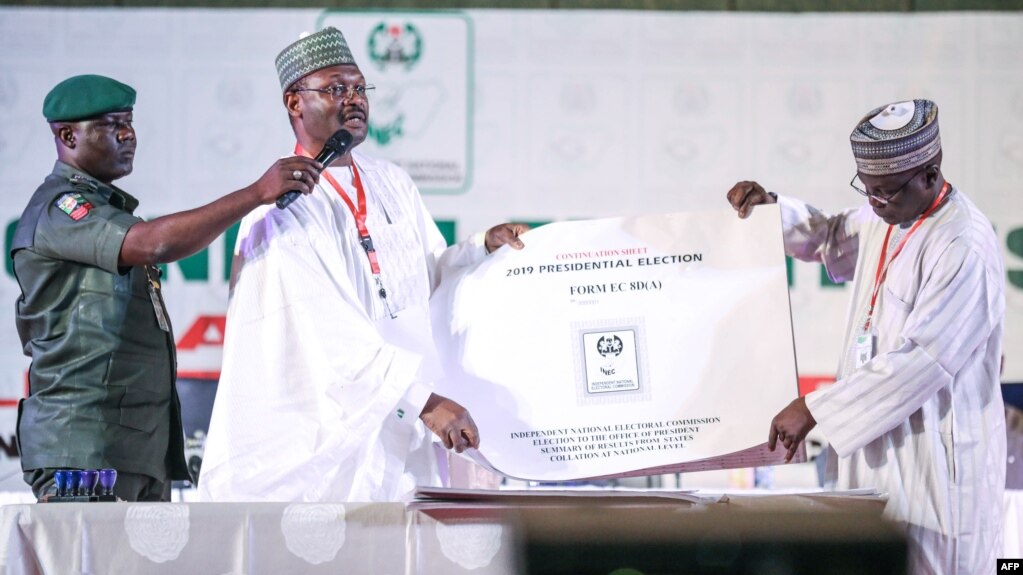 Nigeria's Independent National Electoral Commission (INEC) chairman Mahmood Yakubu displays vote result sheets on Feb. 25, 2019 in Abuja