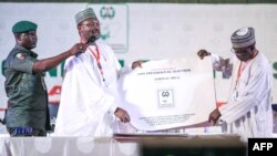 Nigeria's Independent National Electoral Commission (INEC) chairman Mahmood Yakubu displays vote result sheets on Feb. 25, 2019 in Abuja