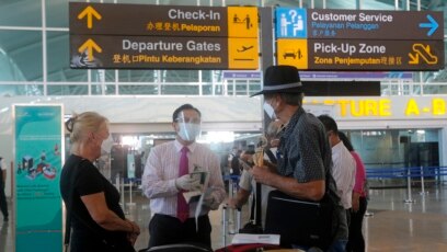 Petugas bandara memeriksa warga Australia setibanya di bandara internasional Ngurah Rai, Bali, 18 Agustus 2021. (AP Photo/Firdia Lisnawati)