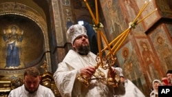 FILE - Metropolitan Epiphaniy, the head of the newly-formed independent Ukrainian Orthodox Church, conducts a service in St. Sophia Cathedral in Kyiv, Ukraine, Jan. 7, 2019.