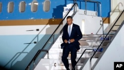 U.S. President Barack Obama steps down the ramp upon his arrival at Haneda International Airport in Tokyo, Wednesday, April 23, 2014. President Obama is in Japan for a three-day state visit. (AP Photo/Shizuo Kambayashi)