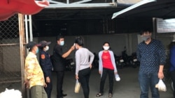 Security guards at Propitious (Cambodia) Garment Ltd. factory routinely check workers' temperature, Kandal province, Cambodia, March 20, 2020. (Kann Vicheika/VOA Khmer)