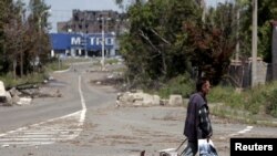 Seorang pria berjalan di jalan yang dikuasai oleh pemberontak di Donetsk, Ukraina, 18 Juli 2015.