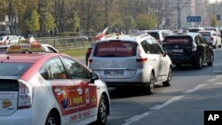 Taxi drivers drive slowly through the capital city downtown causing some traffic jams in protest against low earnings and competition from unlicensed companies like Uber, in Warsaw, Oct. 18, 2018. 