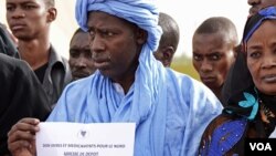 People in the Malian capital, Bamako, hold signs with information about where to drop donations for communities affected by unrest in the north. 8 April 2012. 