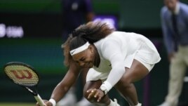 Serena Williams of the US falls to the ground during the women's singles first round match against Aliaksandra Sasnovich of Belarus on day two of the Wimbledon Tennis Championships in London, Tuesday June 29, 2021. (AP Photo/Kirsty Wigglesworth)