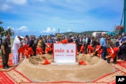 In this photo provided by Cambodia's Fresh News, Cambodian Defense Minister Tea Banh, rear center left, and Chinese Ambassador to Cambodia Wang Wentian, rear center right, preside over the groundbreaking ceremony for a shipyard repairing and restoration workshop in Ream Cambodian Naval Base of Sihanoukville, Wednesday, June 8, 2022. (Cambodia's Fresh News via AP)