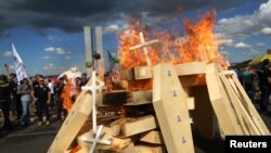 Striking police officers set fire to coffins during a protest by Police officers from several Brazilian states against pension reforms proposed by Brazil's president Michel Temer, in Brasilia, Brazil April 18, 2017. 