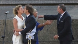 El nuevo presidente de Uruguay, Luis Lacalle Pou, y su esposa Lorena Ponce de León se besan, a la izquierda, mientras la vicepresidenta Beatriz Argimon, segunda a la derecha, es abrazada por el líder del Partido Nacional, Alvaro Delgado, después de prestar juramento en Montevideo, Uruguay, el domingo 1 de marzo de 2020.