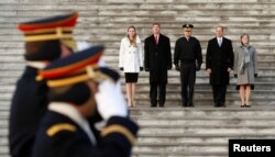 Soldiers salute as they march past stand-ins for President-elect Donald Trump, and his wife Melania (L) and Vice President-elect Mike Pence and his wife Karen (R) during a rehearsal for the inauguration on the East Front of the U.S. Capitol in Washington,