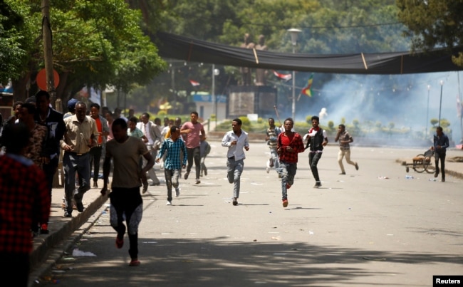 FILE - Protesters run from tear gas being fired by police during Irreecha, the thanks giving festival of the Oromo people in Bishoftu town of Oromia region, Ethiopia, Oct. 2, 2016