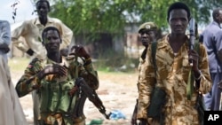 Des soldats de l'armée gouvernementale en patrouille dans le village de Bentiu, Soudan du Sud, 24 juin 2015