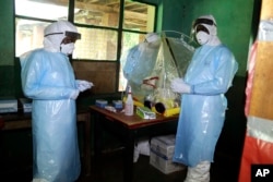 Health care workers wear virus protective gear at a treatment center in Bikoro Democratic Republic of Congo,May 13, 2018.