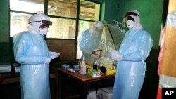 FILE - Health care workers wear virus protective gear at a treatment center in Bikoro Democratic Republic of Congo, May 13, 2018. 